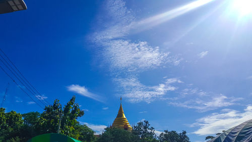 Low angle view of trees against blue sky