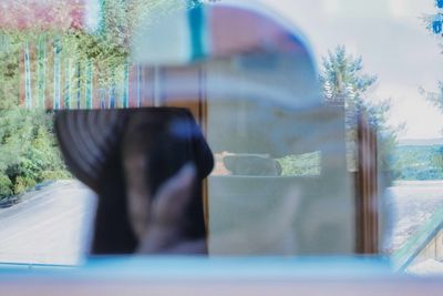 Portrait of woman photographing through car window