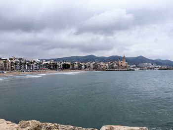 View of cityscape against cloudy sky