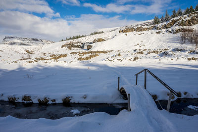 Scenic view of snow covered field against sky