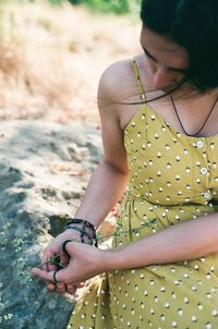 Midsection of woman sitting outdoors