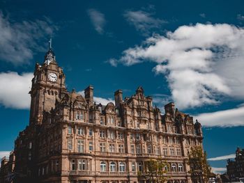 Low angle view of buildings against cloudy sky