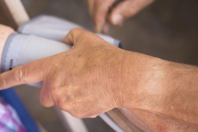 Cropped image of doctor holding patient bandage in hospital