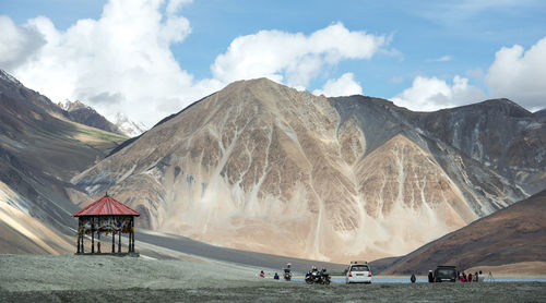 People hiking on landscape against sky