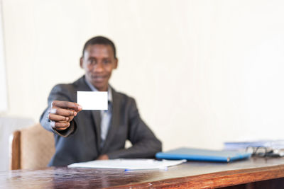 Portrait of man holding smart phone on table