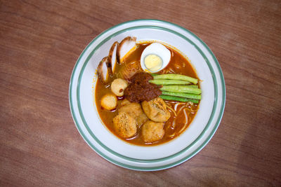 Directly above shot of food served in plate on wooden table