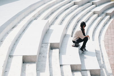 High angle view of woman sitting on steps at amphitheater