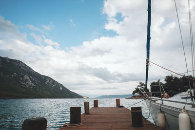 Wooden posts in sea against sky