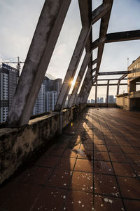 Footpath amidst buildings against sky during sunset