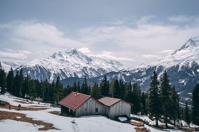 Houses on snow covered landscape against sky