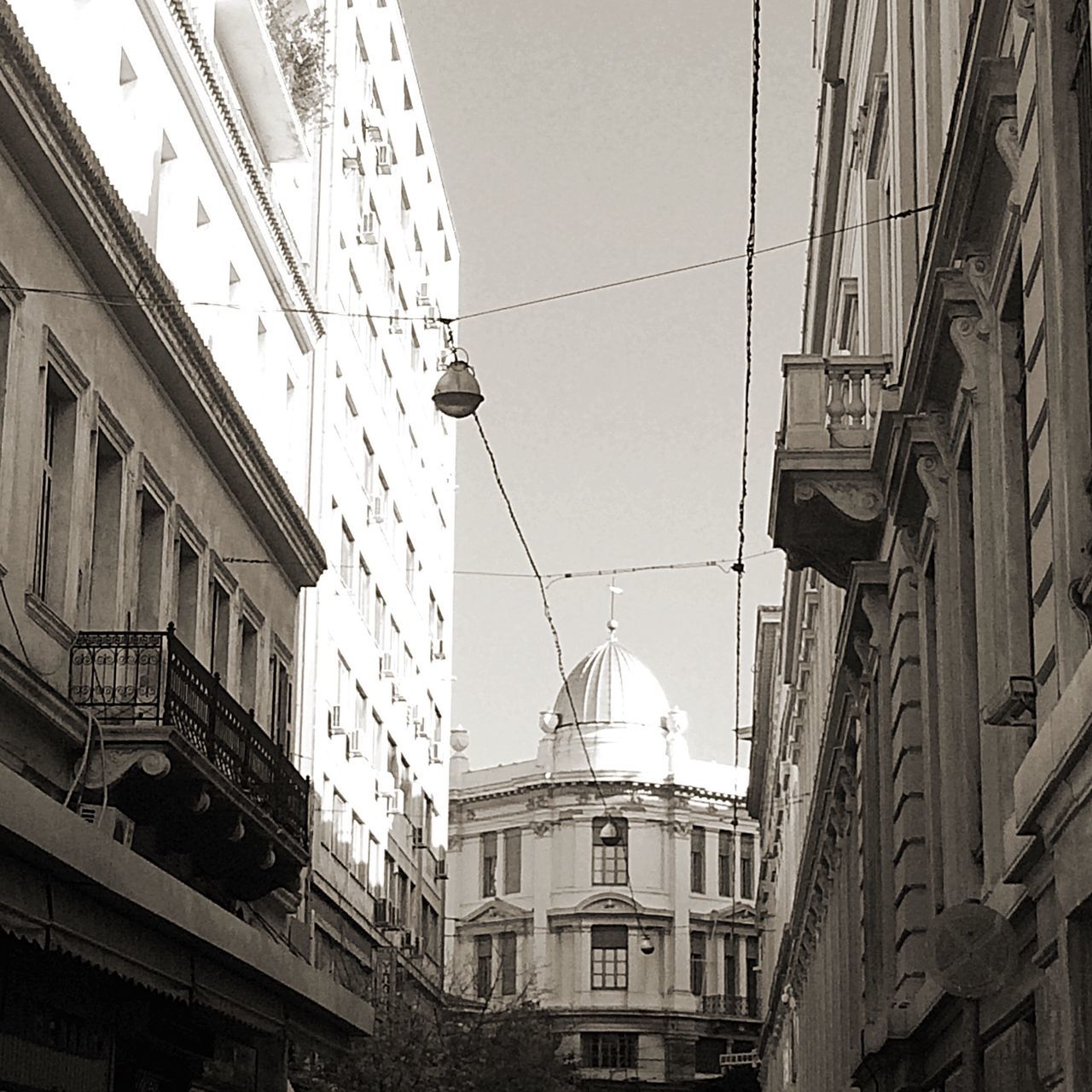 building exterior, architecture, built structure, clear sky, residential building, city, residential structure, low angle view, building, power line, cable, house, day, sky, outdoors, residential district, window, street, no people, city life