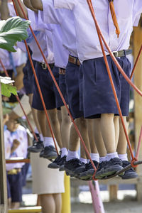 Low section of students standing on rope at playground