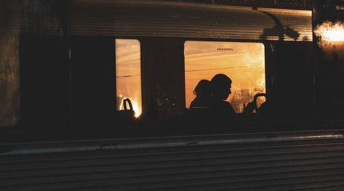 Silhouette people sitting in illuminated train at night