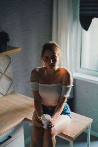 Woman sitting on table at home