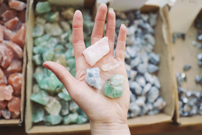 Cropped hand of woman holding crystals in store