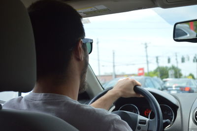 Side view of man driving car