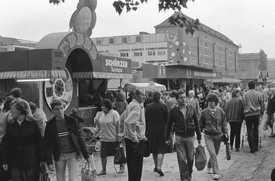 People on street in city against sky