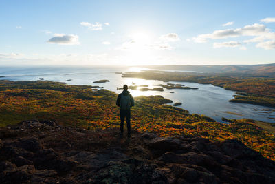 Man standing at sea shore against sky