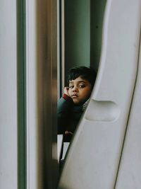 Portrait of boy looking through window
