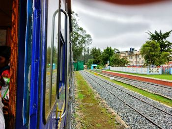 Railroad tracks by trees against sky