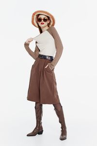 Portrait of young woman standing against white background