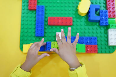 Cropped hands playing with toy blocks