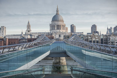 Buildings in city against cloudy sky