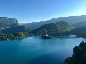 Scenic view of sea and mountains against blue sky