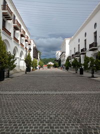 Walkway in city against sky