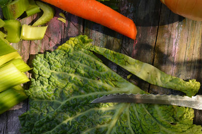 Cutting up savoy cabbage leaf, celery, carrot for cabbage soup