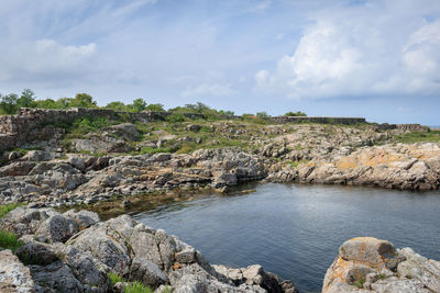 Rock formations by sea against sky