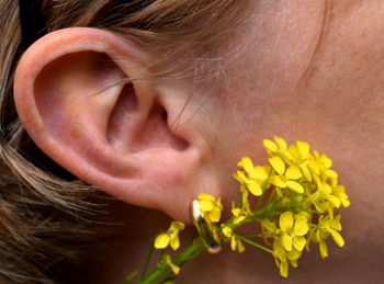 Close-up of woman with pink flower