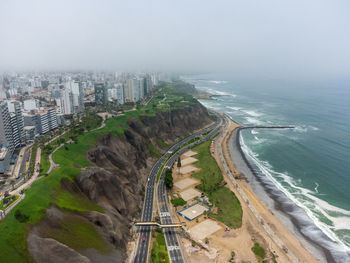 High angle view of buildings and sea against sky