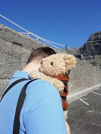 Portrait of man on road against clear blue sky