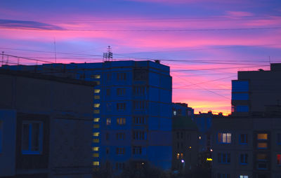 Silhouette buildings against sky at sunset
