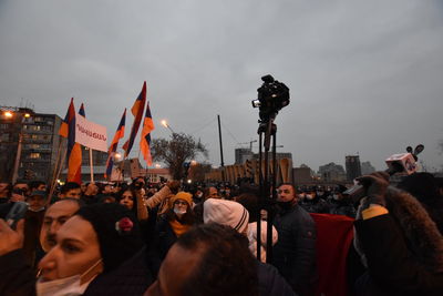 People on street in city against sky