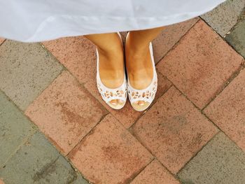 Low section of woman standing on tiled floor