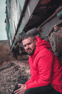 Portrait of man sitting against train