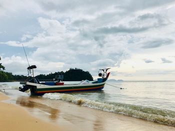 Boat moored on sea against sky