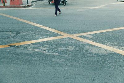 Low section of man skateboarding on road