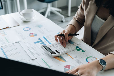Midsection of business colleagues working on table
