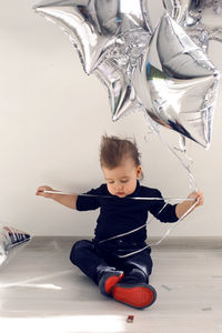 Child sits on the floor with balloons in the form of stars