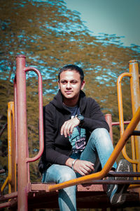 Portrait of young man sitting on seat