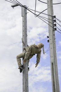Low angle view of statue on pole against sky