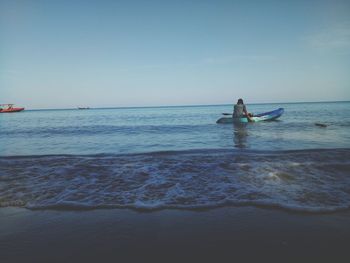 Rear view of man sitting on kayak in sea