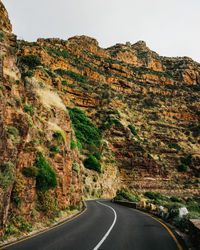 Road leading towards mountains against sky