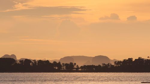 Scenic view of lake against orange sky