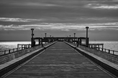 Pier over sea against sky during sunset