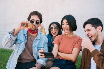 Cheerful friends having fun while sitting outdoors