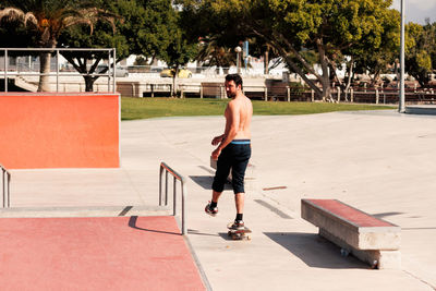 Man riding skateboard in urban street skatepark. casual guy wearing shorts and t-shirt.